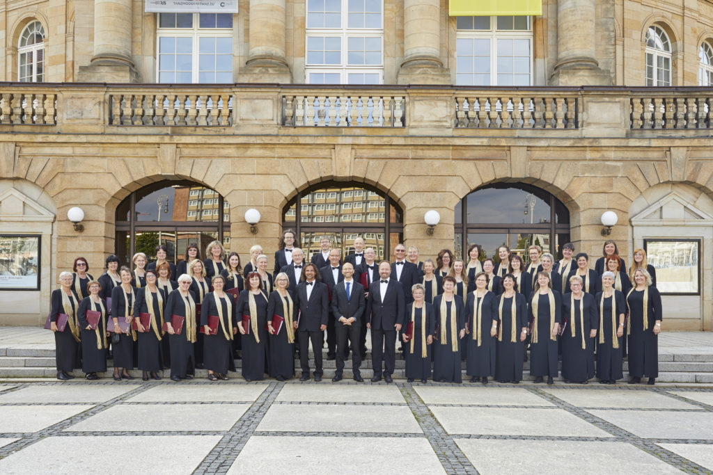 Sängerinnen und Sänger der Singakademie mit künstlerischem Leiter vor dem Opernhaus Chemnitz